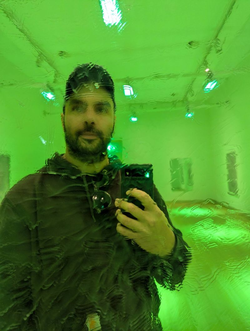 Gilad's reflection in a rippling mirror under green light
